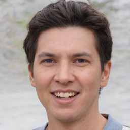 Joyful white adult male with short  brown hair and grey eyes