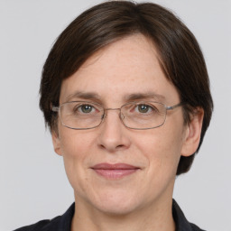 Joyful white adult female with medium  brown hair and grey eyes