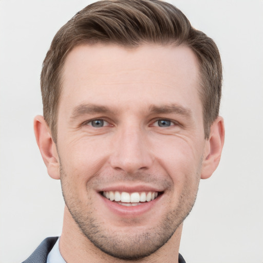 Joyful white young-adult male with short  brown hair and grey eyes