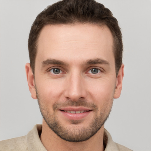 Joyful white young-adult male with short  brown hair and grey eyes