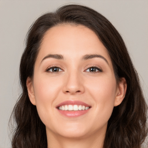 Joyful white young-adult female with long  brown hair and brown eyes