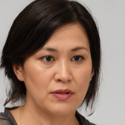 Joyful asian adult female with medium  brown hair and brown eyes