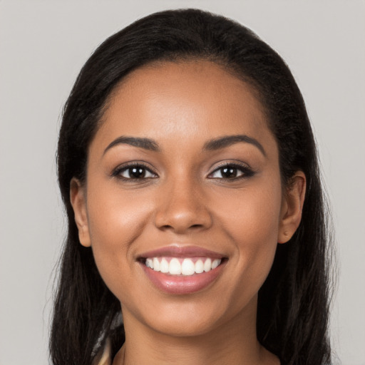 Joyful latino young-adult female with long  black hair and brown eyes