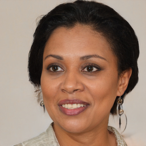 Joyful black adult female with medium  brown hair and brown eyes
