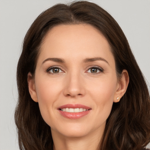 Joyful white young-adult female with long  brown hair and brown eyes