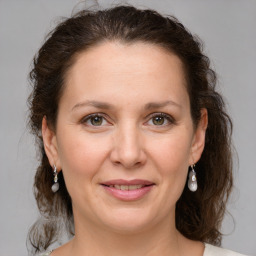 Joyful white adult female with medium  brown hair and grey eyes