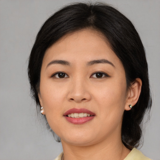 Joyful asian young-adult female with medium  black hair and brown eyes