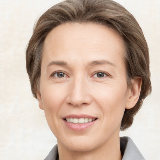 Joyful white adult female with medium  brown hair and grey eyes