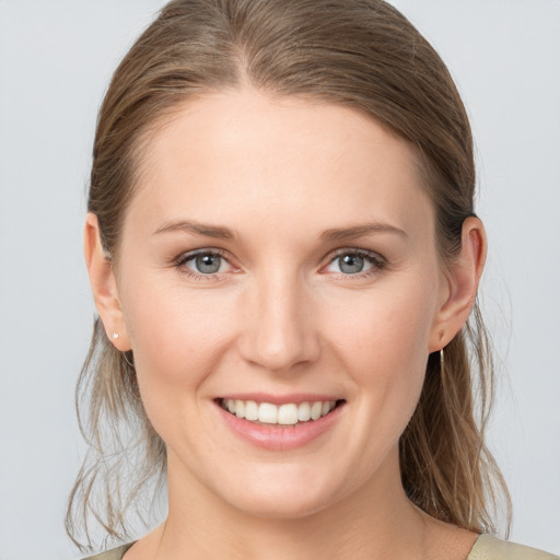 Joyful white young-adult female with medium  brown hair and grey eyes