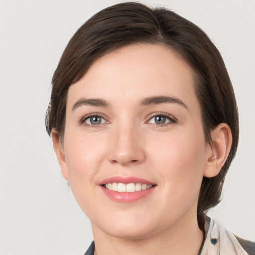 Joyful white young-adult female with short  brown hair and grey eyes