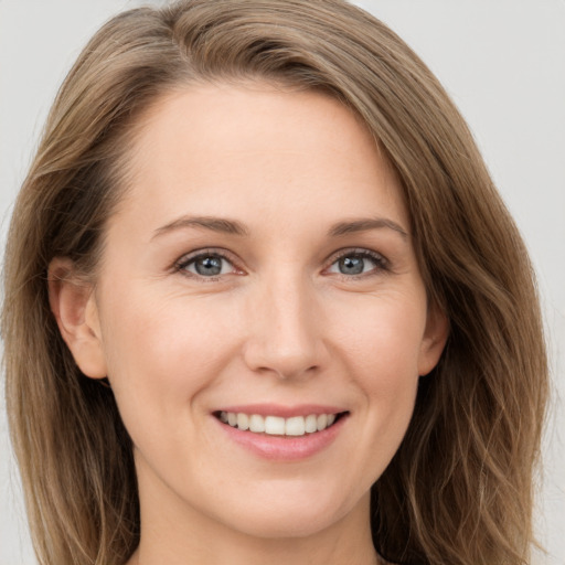 Joyful white young-adult female with long  brown hair and grey eyes