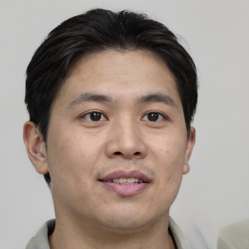 Joyful asian young-adult male with short  brown hair and brown eyes