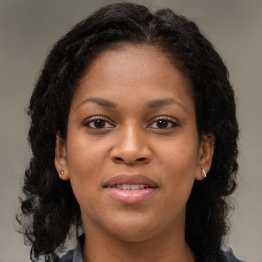 Joyful black young-adult female with long  brown hair and brown eyes