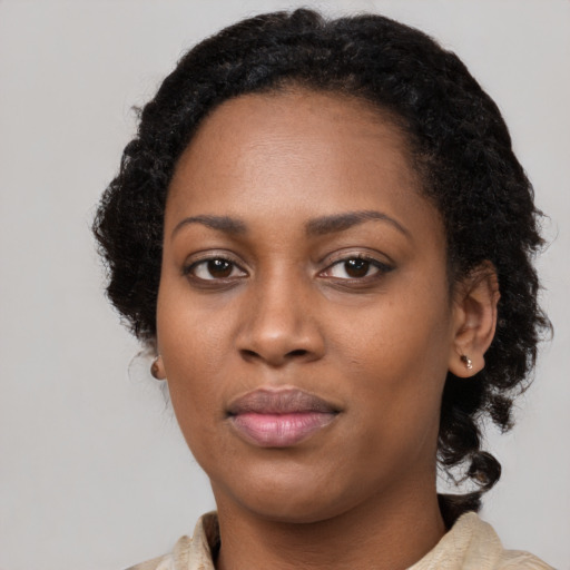 Joyful black young-adult female with long  brown hair and brown eyes