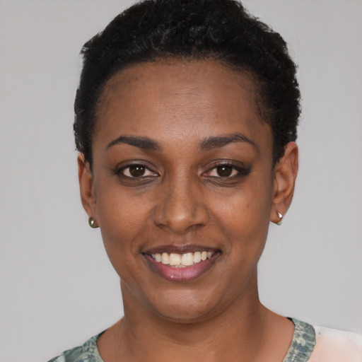 Joyful black young-adult female with short  black hair and brown eyes