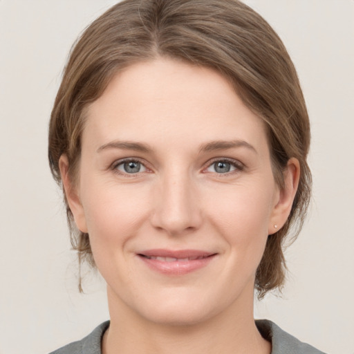 Joyful white young-adult female with medium  brown hair and grey eyes