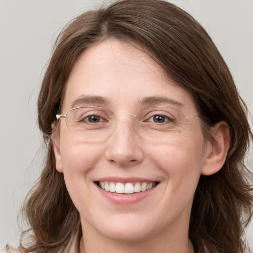 Joyful white adult female with long  brown hair and grey eyes