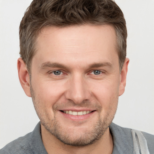 Joyful white adult male with short  brown hair and grey eyes