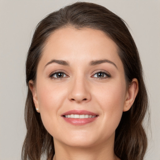 Joyful white young-adult female with long  brown hair and grey eyes