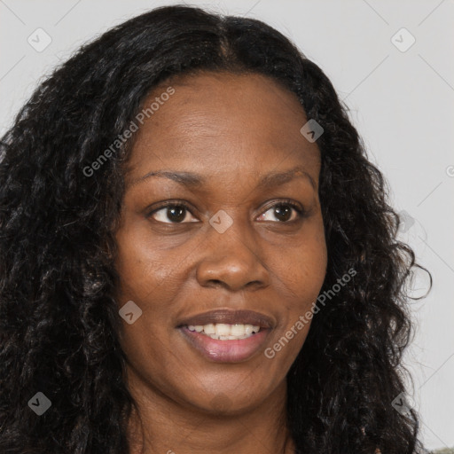 Joyful black young-adult female with long  brown hair and brown eyes