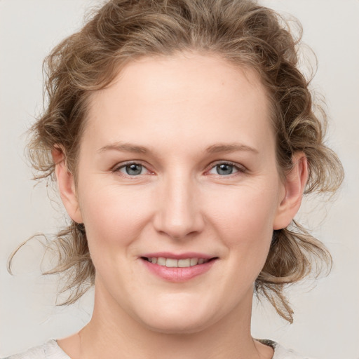 Joyful white young-adult female with medium  brown hair and blue eyes