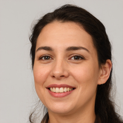 Joyful white young-adult female with long  brown hair and brown eyes