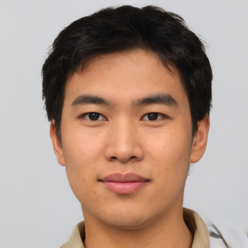 Joyful asian young-adult male with short  brown hair and brown eyes