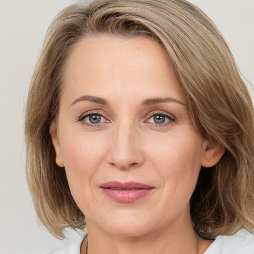 Joyful white adult female with medium  brown hair and grey eyes