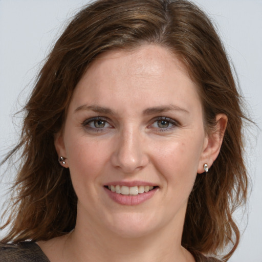 Joyful white young-adult female with medium  brown hair and grey eyes