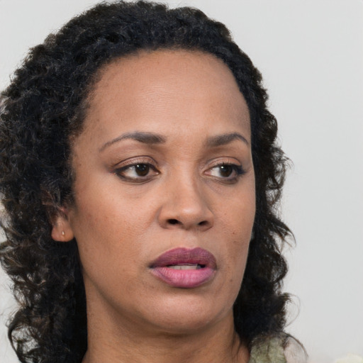 Joyful black adult female with long  brown hair and brown eyes
