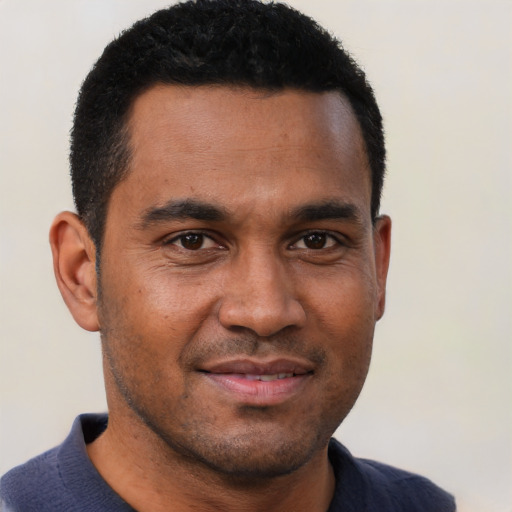 Joyful black young-adult male with short  brown hair and brown eyes