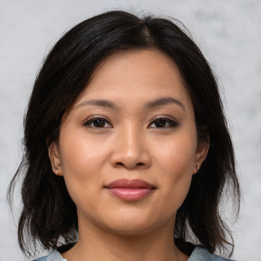 Joyful asian young-adult female with medium  brown hair and brown eyes