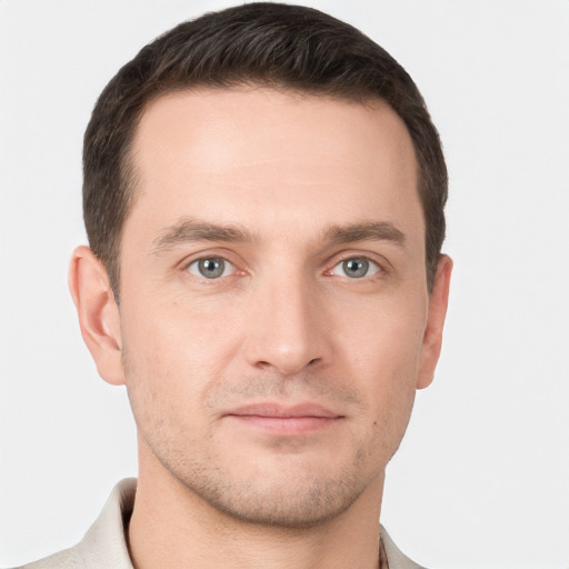 Joyful white young-adult male with short  brown hair and grey eyes