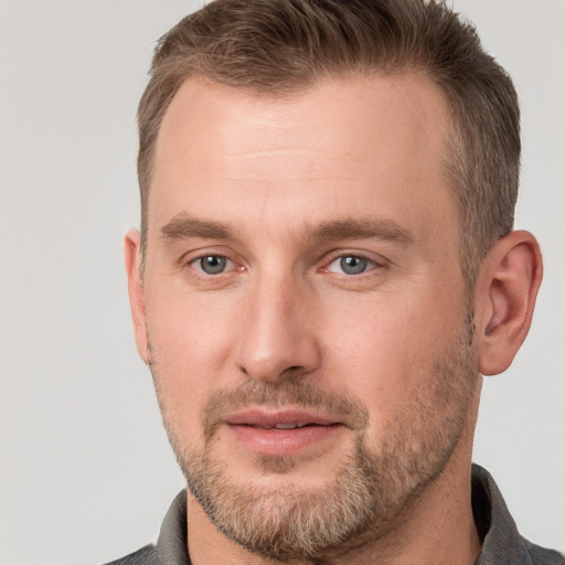 Joyful white adult male with short  brown hair and grey eyes