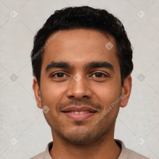 Joyful latino young-adult male with short  black hair and brown eyes