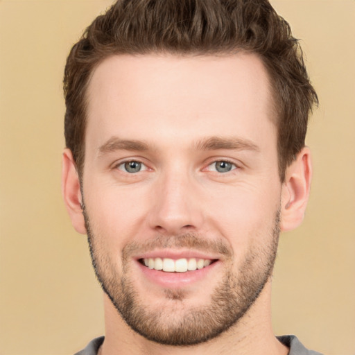 Joyful white young-adult male with short  brown hair and grey eyes