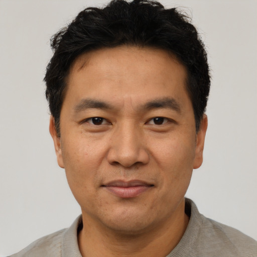 Joyful asian adult male with short  black hair and brown eyes