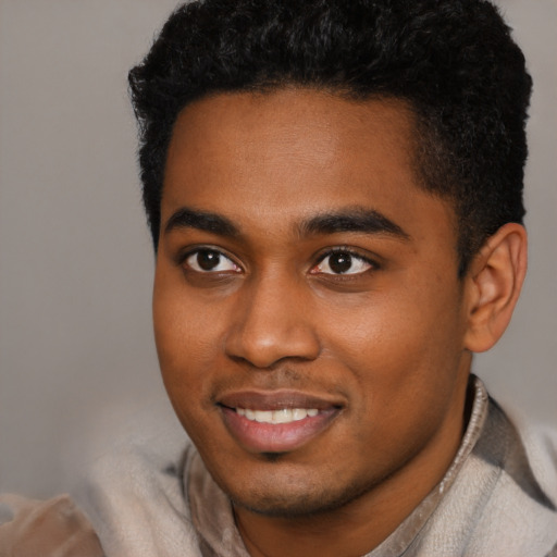 Joyful black young-adult male with short  black hair and brown eyes