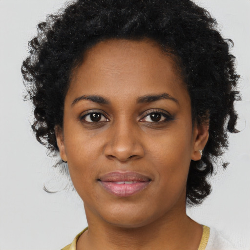 Joyful black young-adult female with short  black hair and brown eyes