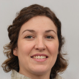 Joyful white adult female with medium  brown hair and green eyes