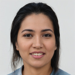 Joyful latino young-adult female with medium  brown hair and brown eyes