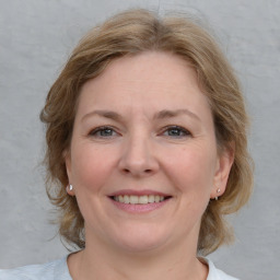 Joyful white young-adult female with medium  brown hair and blue eyes