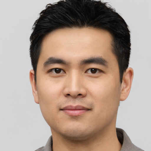 Joyful asian young-adult male with short  black hair and brown eyes