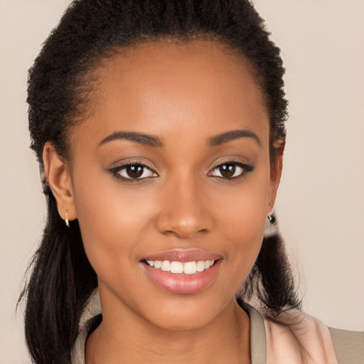 Joyful black young-adult female with long  brown hair and brown eyes