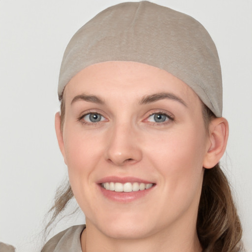 Joyful white young-adult female with medium  brown hair and grey eyes