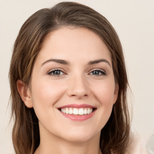 Joyful white young-adult female with long  brown hair and green eyes