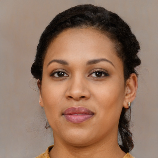 Joyful black young-adult female with long  brown hair and brown eyes