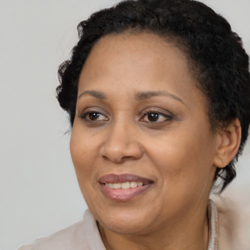 Joyful black adult female with medium  brown hair and brown eyes