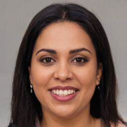 Joyful latino young-adult female with long  brown hair and brown eyes