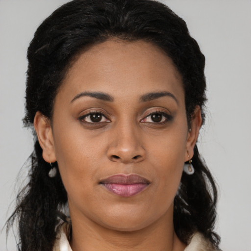 Joyful black young-adult female with long  brown hair and brown eyes